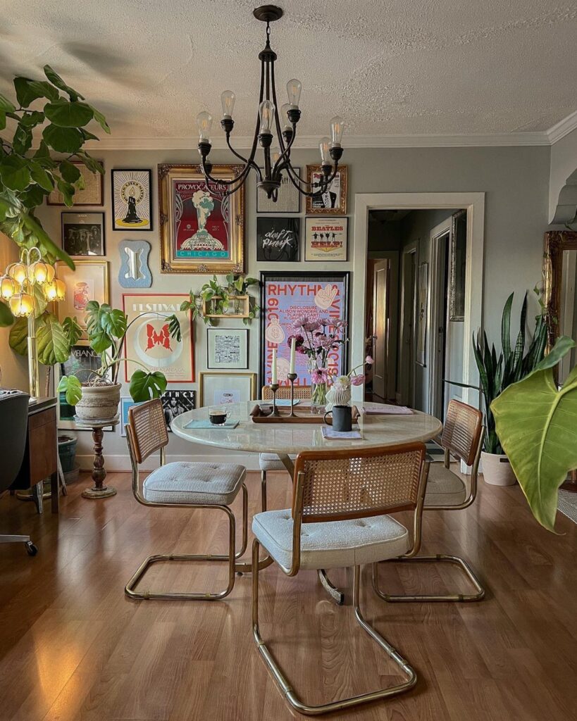 Round marble dining table with gold legs and cane chairs in eclectic room.