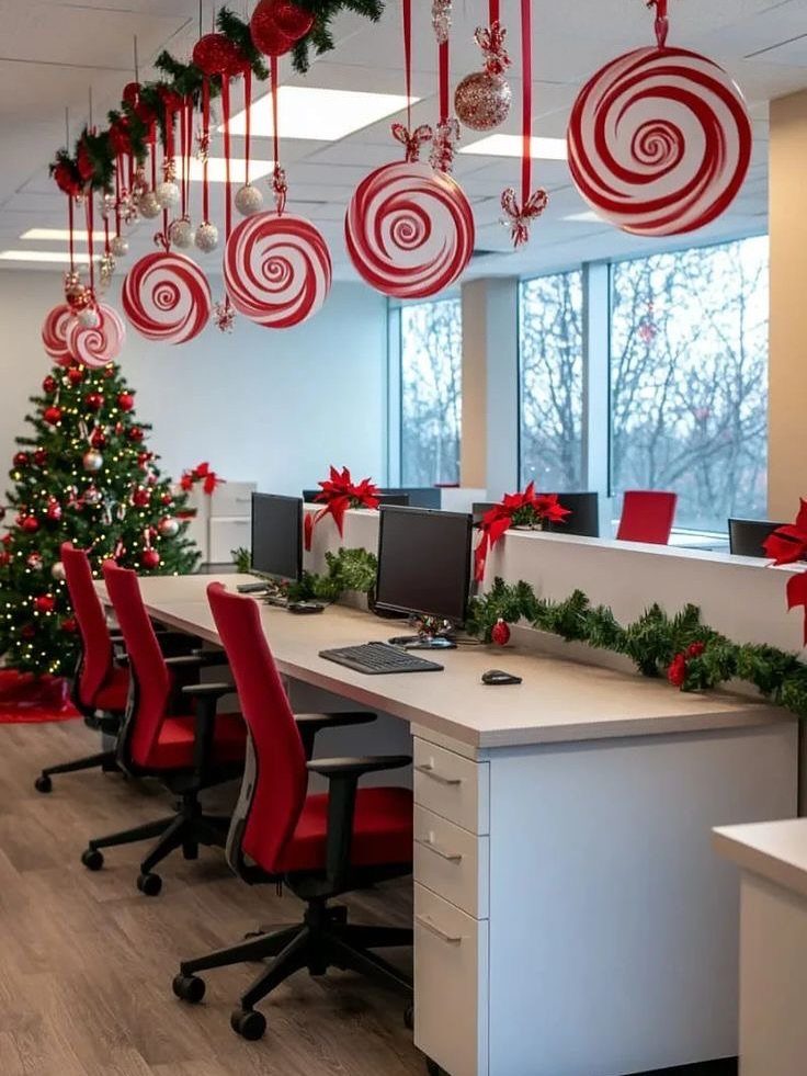 Office workspace decorated with a Christmas tree, red chairs, and hanging peppermint ornaments.
