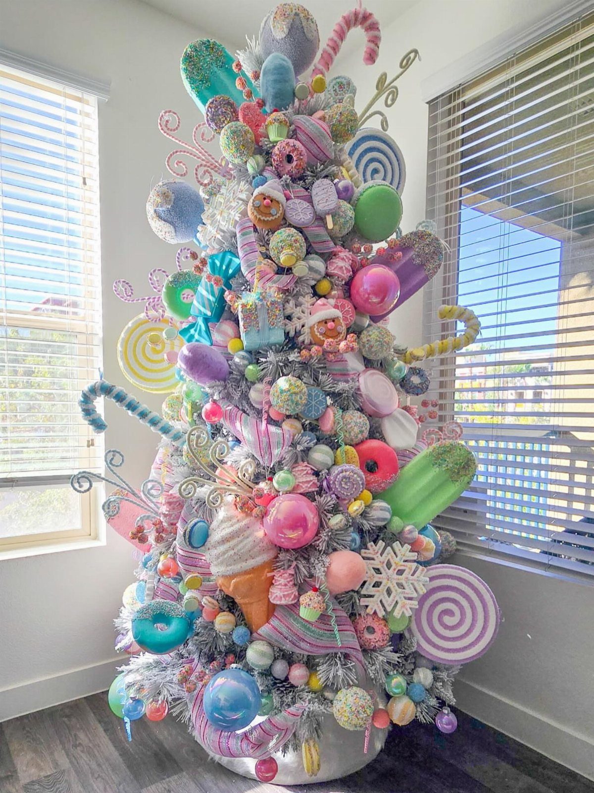 Candy-themed white Christmas tree decorated with oversized colorful sweets and pastel ornaments.