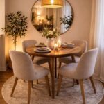 Round wooden dining table with beige chairs and a circular mirror in a cozy room